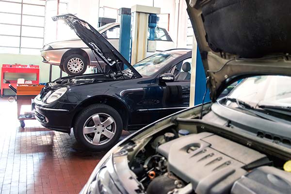 Mechanic working on a car engine in a well-equipped garage, highlighting professional automotive service.