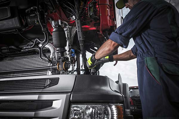 Mechanic conducting an engine inspection, emphasizing quality car care in San Antonio, TX.